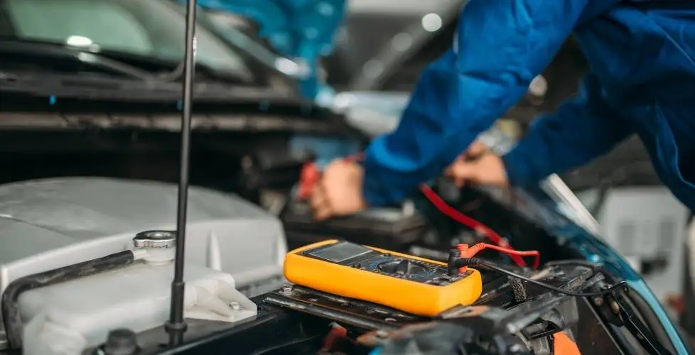 Certified mechanic using a rugged laptop for advanced truck diagnostics Joplin MO inside a commercial truck cab