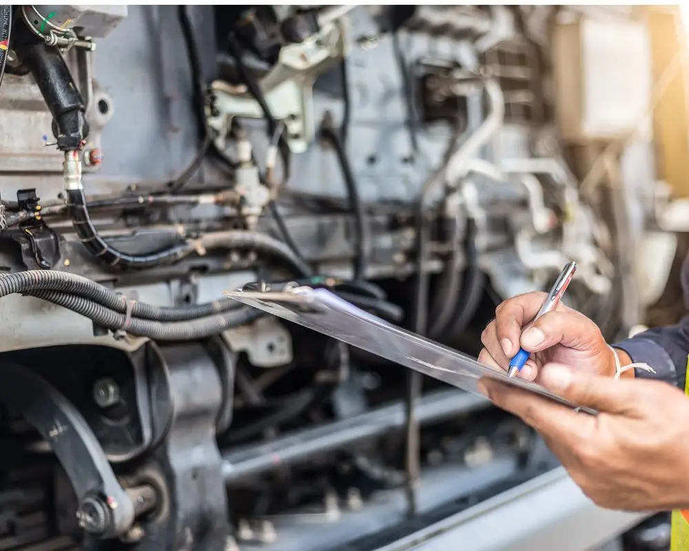 Rapid Truck Repair - Technician wearing a safety vest writes on a clipboard while inspecting the exposed engine of a train.